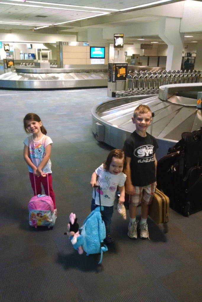 3 kids carry luggage through airport in DFW
