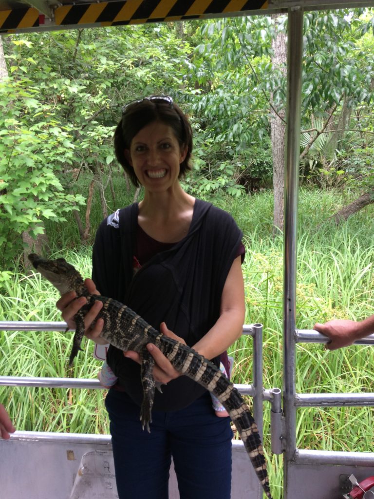 Mom with baby in wrap holding an alligator