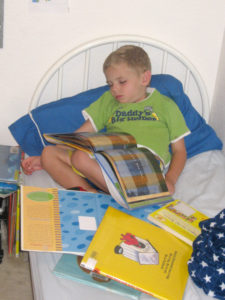 boy sleeping surrounded by books