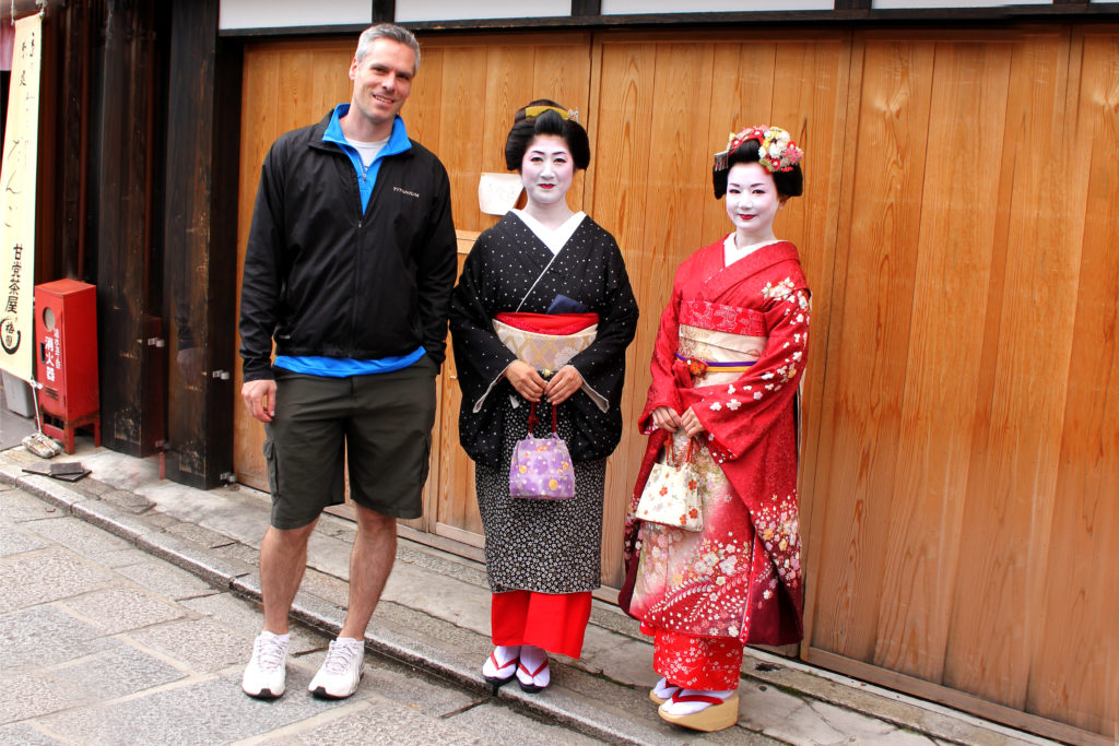 Tall man with beautiful Geisha girls