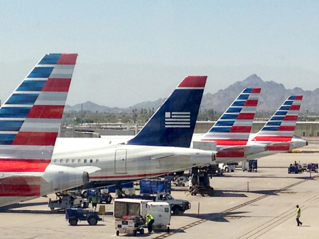 3 American Airline airplane tails with one US Airways airplane tail