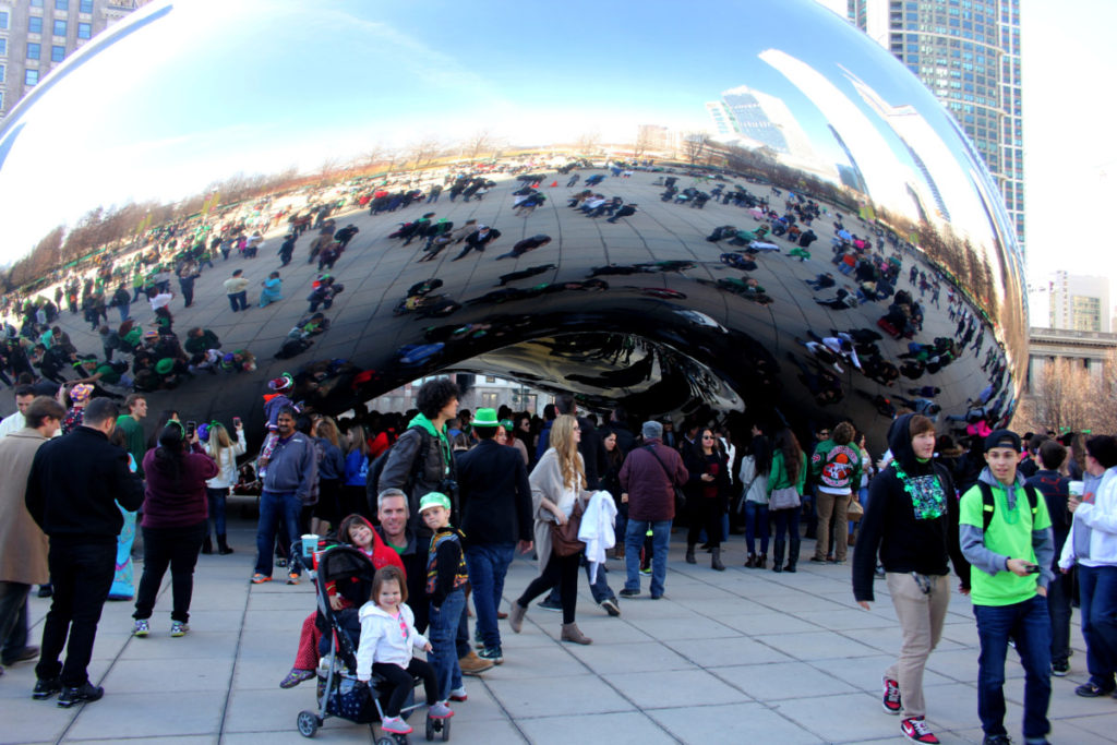 a Family posed in front of the crowded area around Cloud Gate in Chicago
