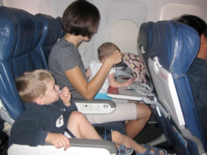 Mom entertaining 2 toddlers on an airplane