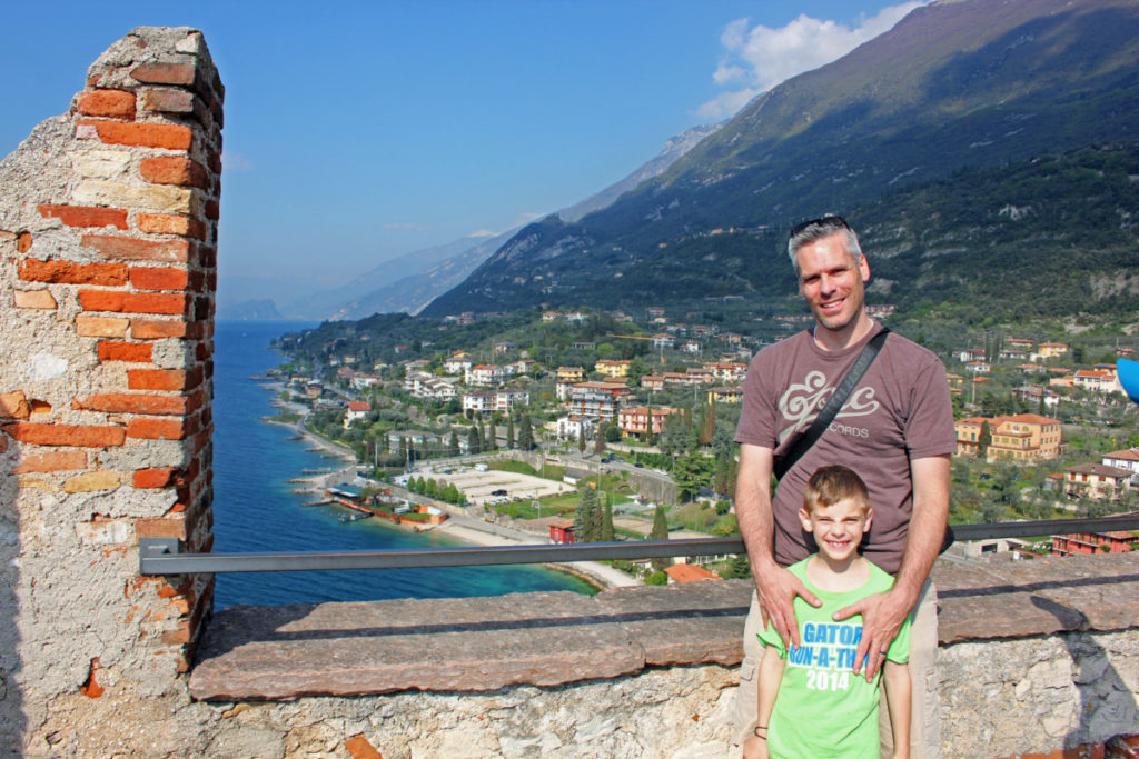 A Man and Son at Scaliger Catle in Malcesine, Italy on Lake Garda with the city and mountain in the background