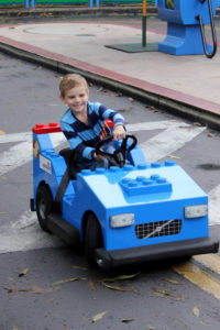 a boy drives a blue lego car are Legoland, near San Diego California
