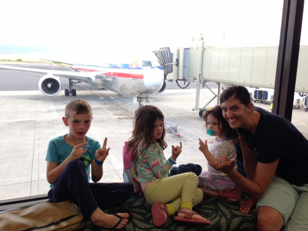 Mom with 3 children flying standby home on a red-eye in the airport waiting to board