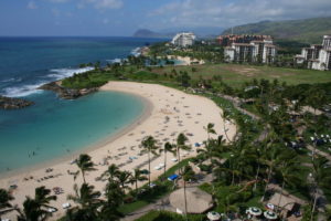 Ariel view of Ko'olina beach with palm trees and mountains in the distance