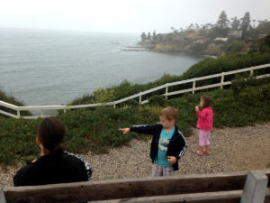 Boy and girl looking over the cliffs near La Jolla, San Diego, California