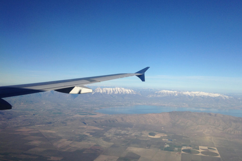 snow-capped mountains seen just below the airplane wing.