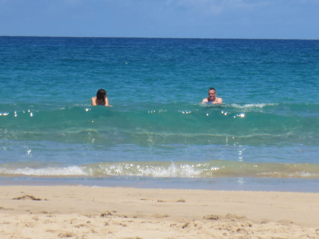 Family plays in the blue green water at Hapuna Beach on the Big island of Hawaii