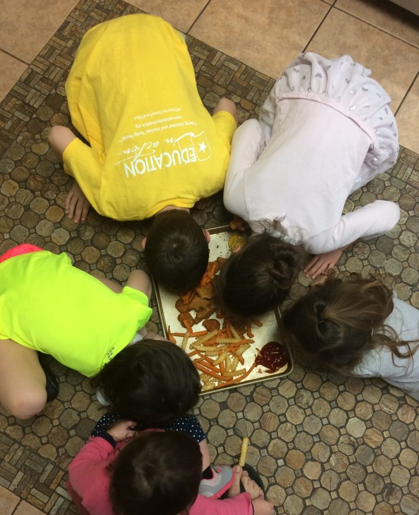 5 kids eat freezer meals from the kitchen floor like dogs