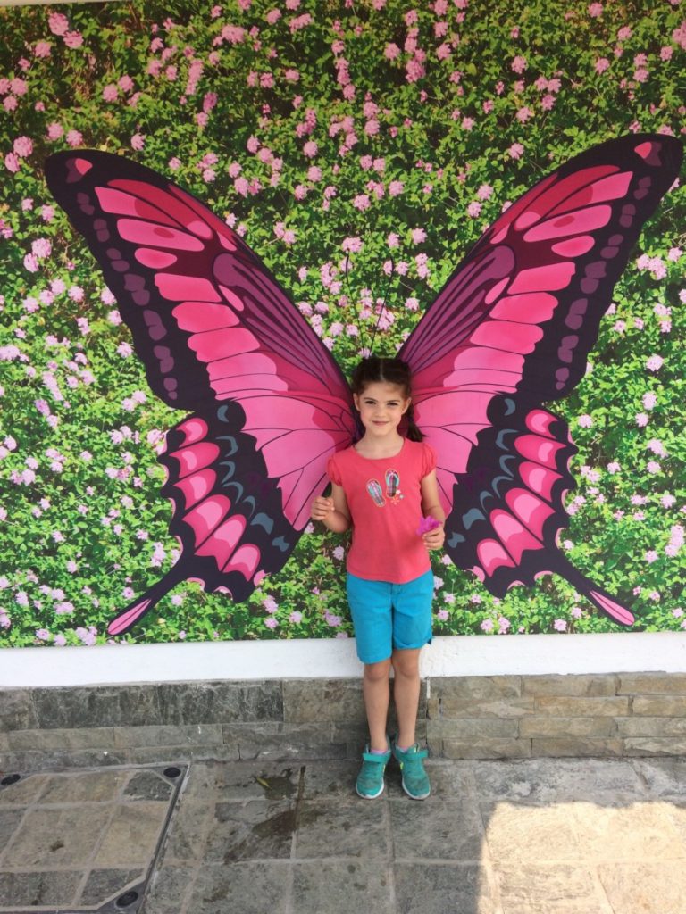 a Young girl poses as a butterfly in artwork in Hong Kong