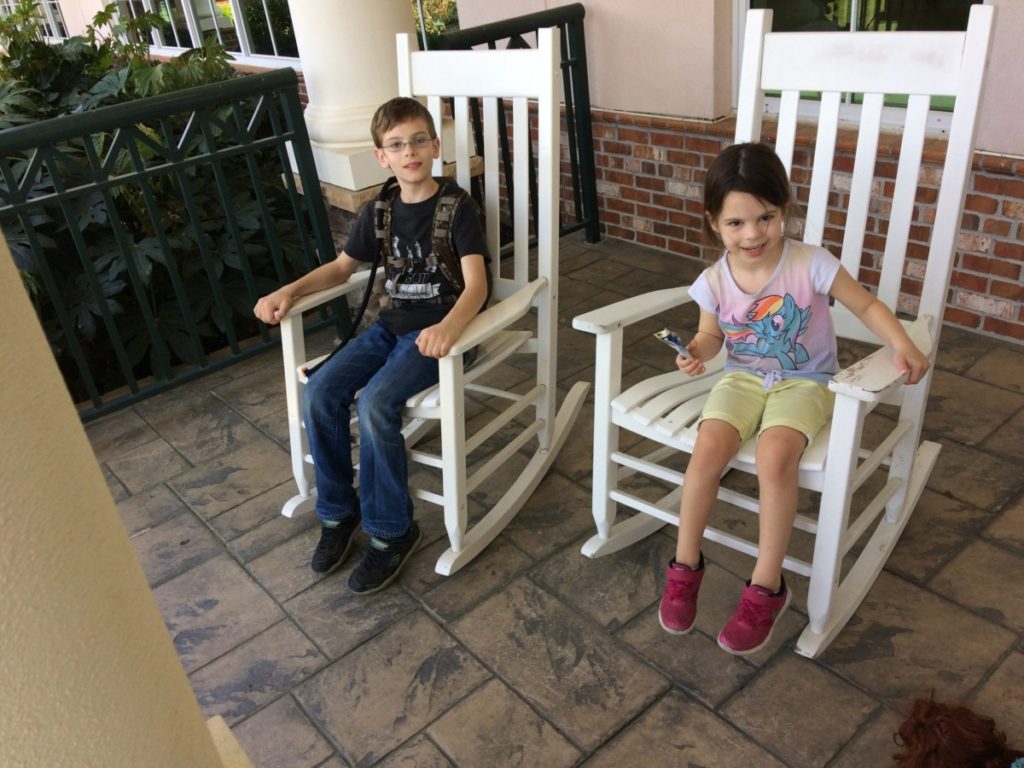 a boy and girl rock in rocking chairs while waiting for a flight traveling as a NonRev passenger