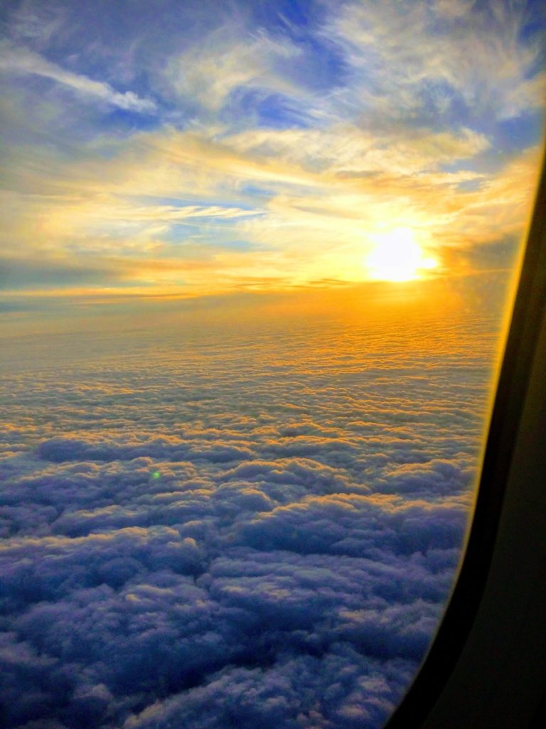 A Golden Sunrise over clouds from an Airplane