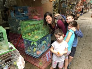 a family around bird cages at the Bird Market in Hong Kong