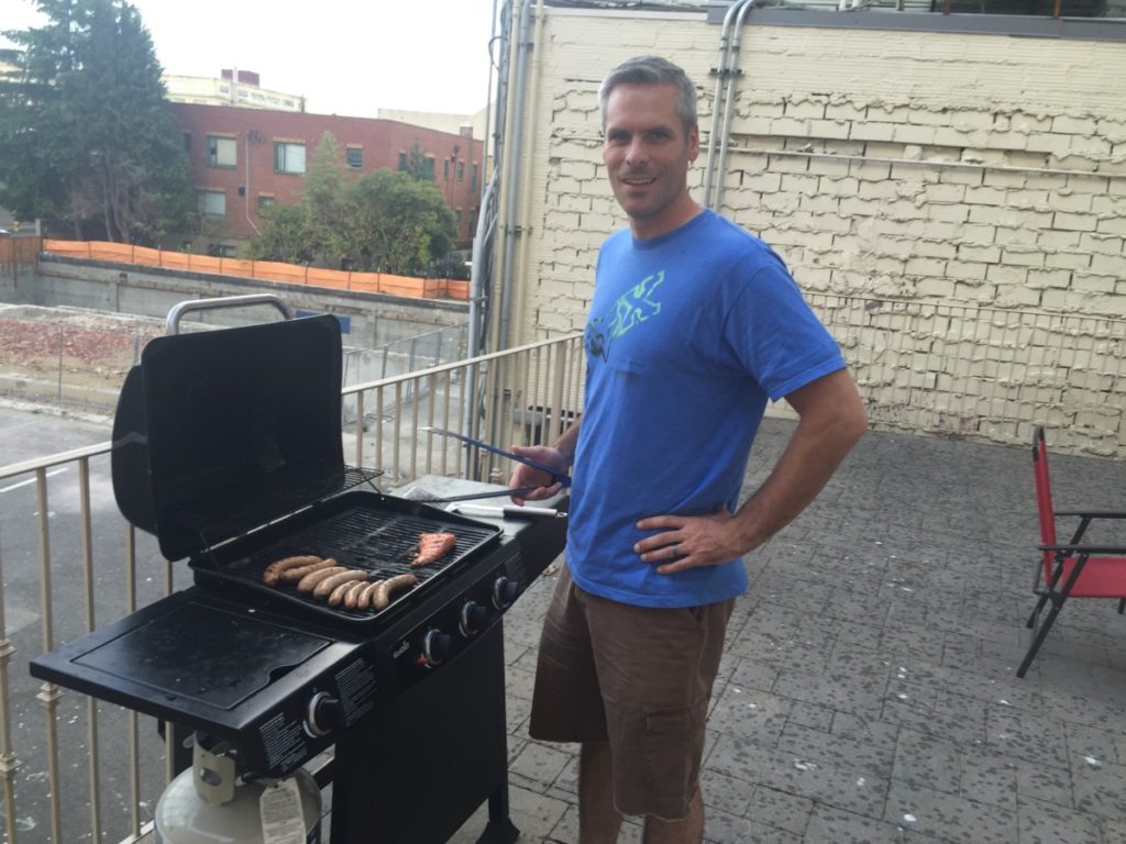 Dad Grills Brats on a grill outdoors
