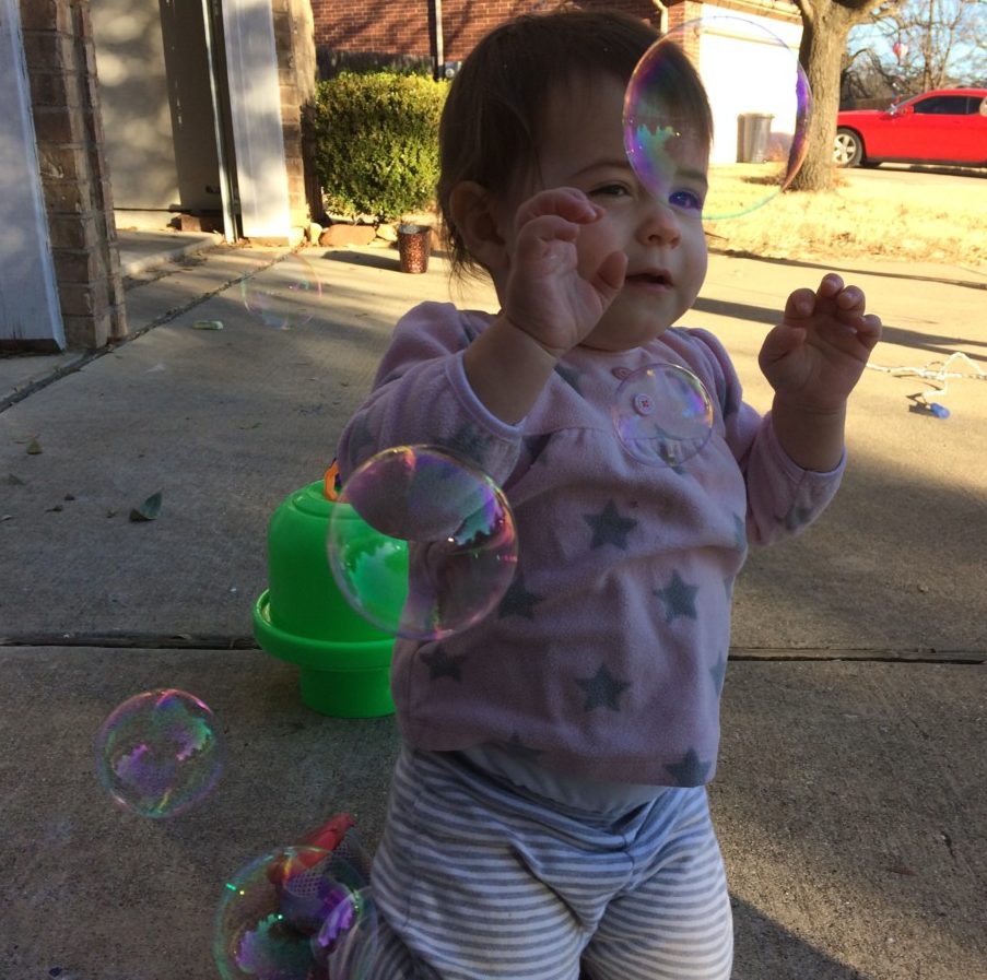 a baby runs from bubbles