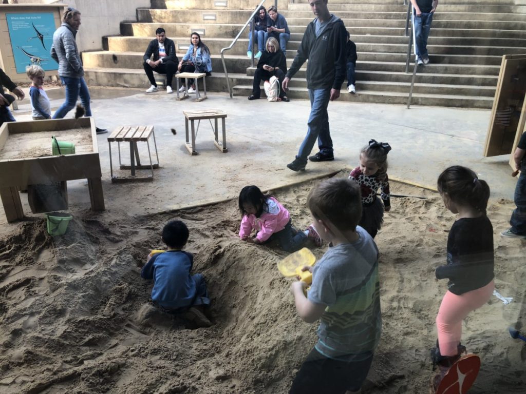 Kids play and dig in Sandbox at Perot Museum