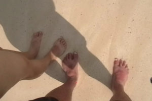 a couple's feet on a sandy beach