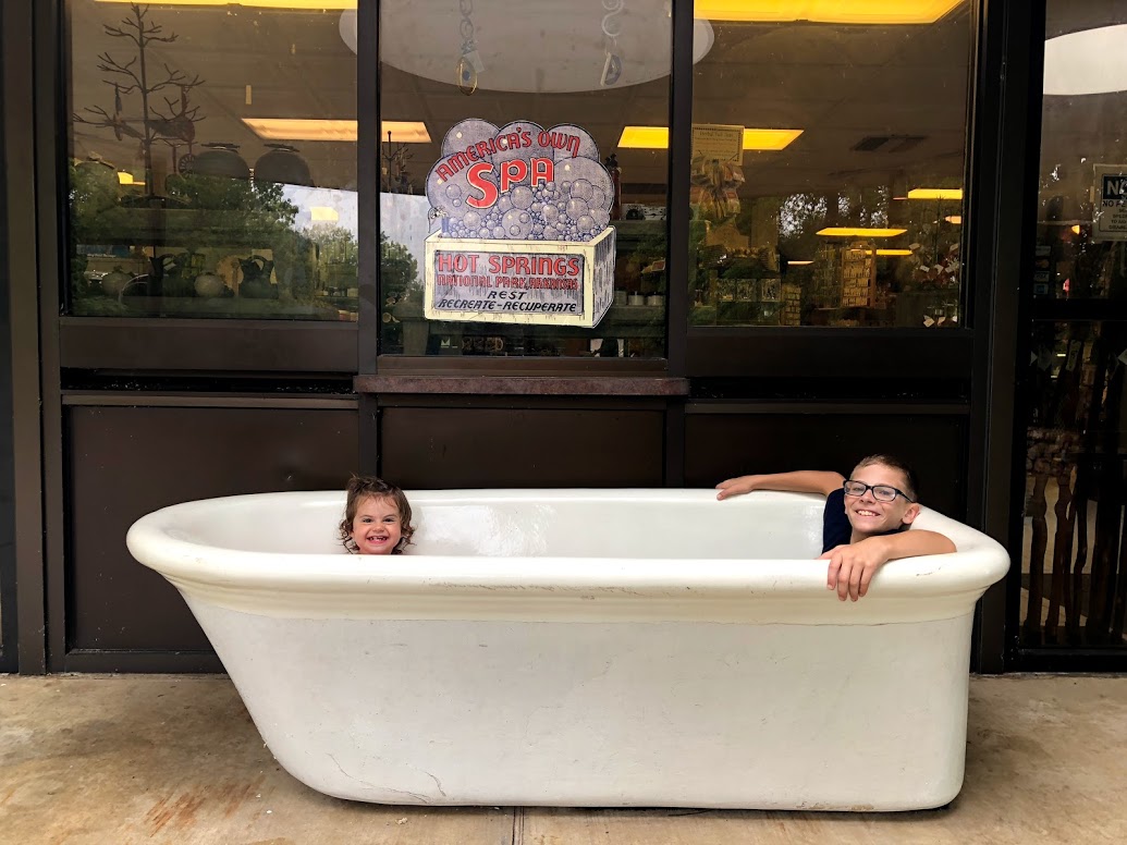 a baby and a young boy in a bath tub at the visitors center at Mountain Tower, Hot Springs National Park