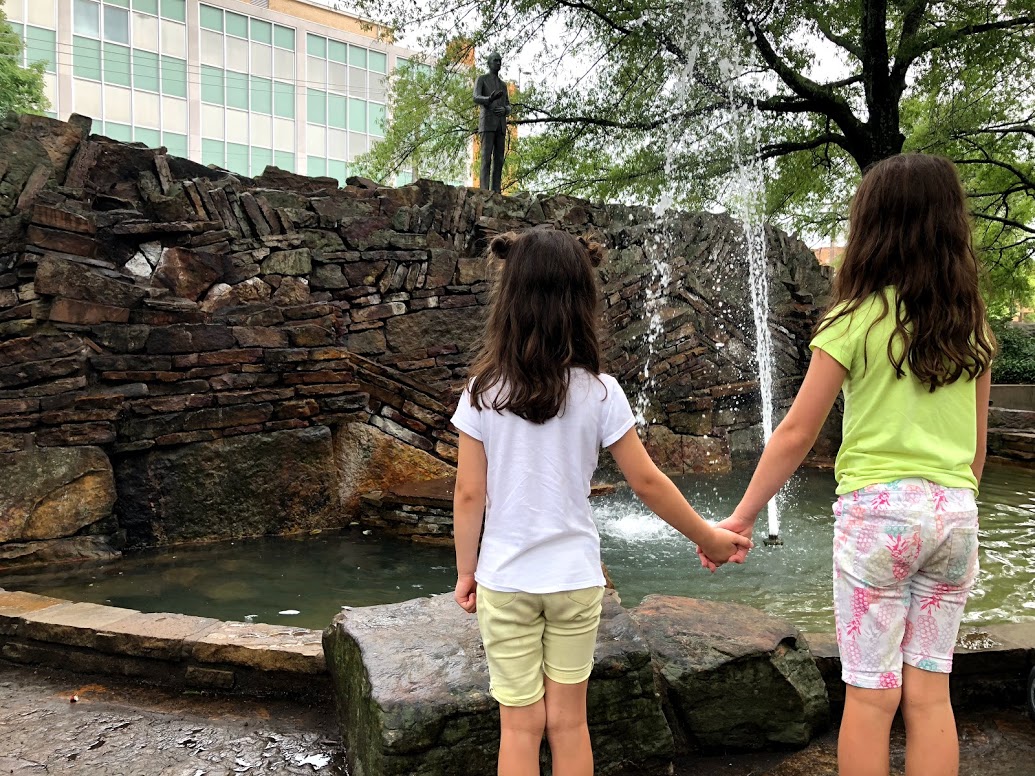 2 girls hold hands looking at Bill clinton park water fountain at Hot Springs National Park
