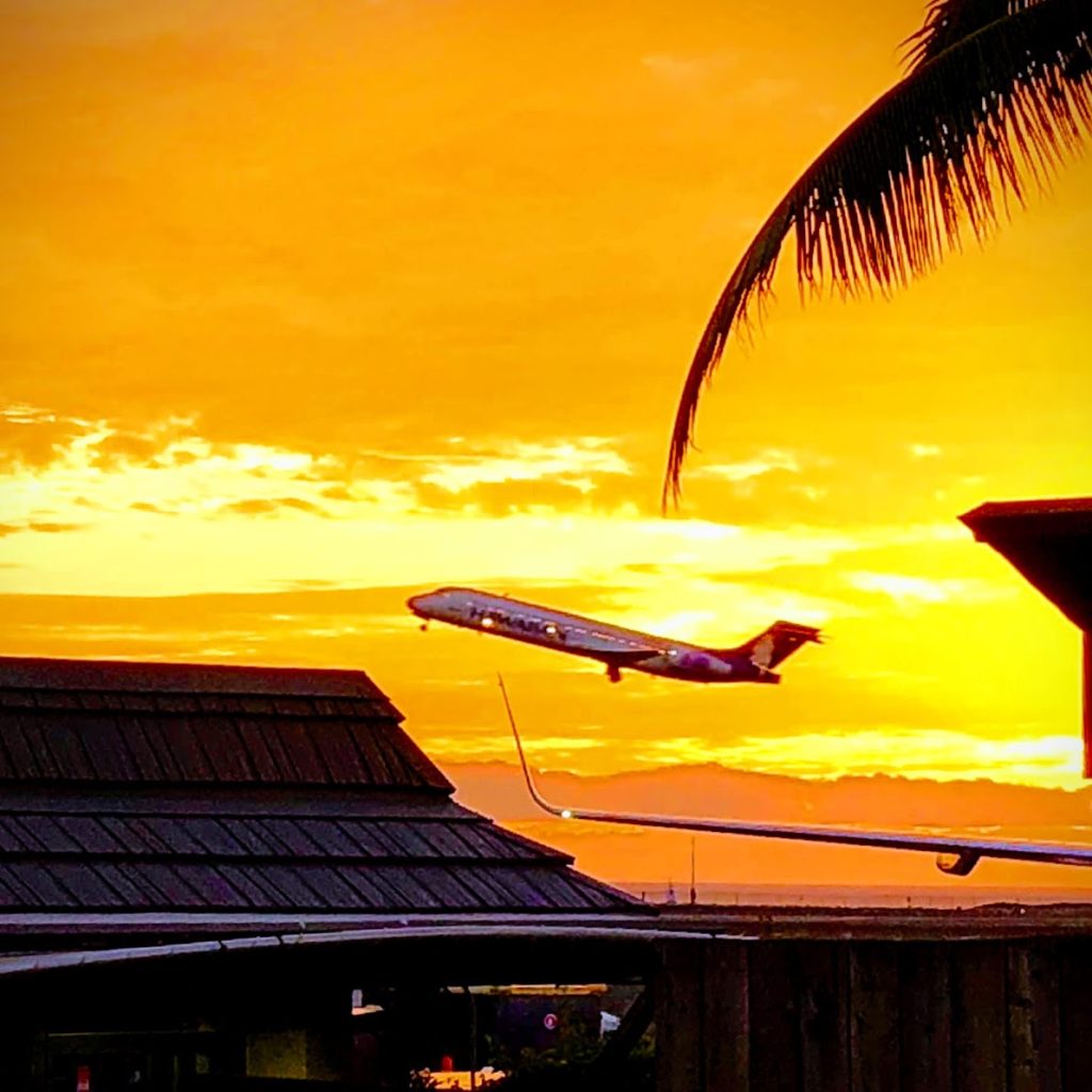Hawaiian Airlines AirPlane takes off in the bright yellow sunset