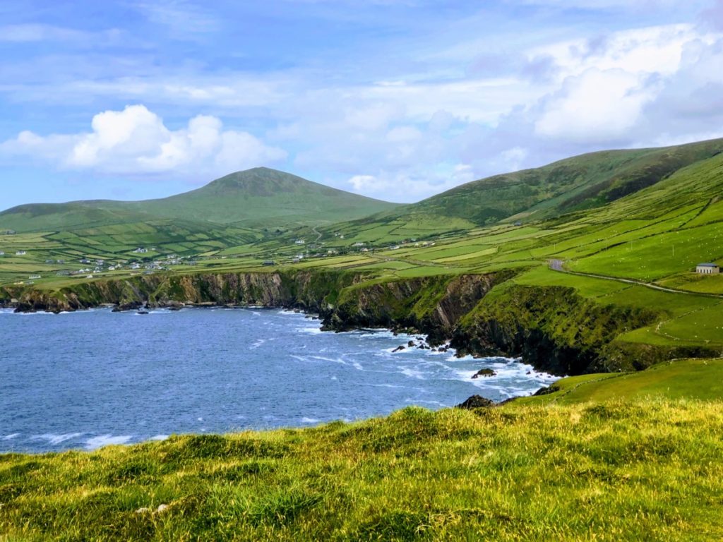 Coastline view of blue waters and green land at Wild Atlantic Way on Slea Head Drive on Dingle Peninsula, Ireland