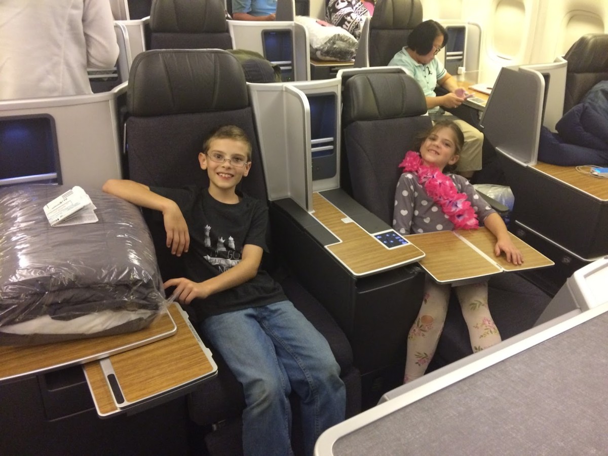2 kids sit in First Class seats