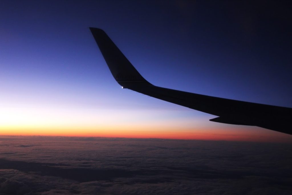 Airplane wing sillohuette in a Blue and orange sunset