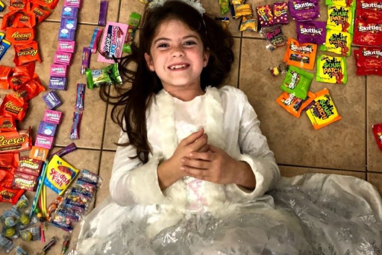 Girl lays in the middle of Her Halloween candy