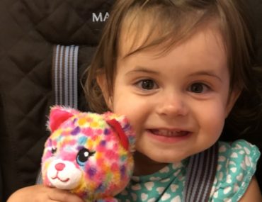 Smiling baby with a stuffed animal