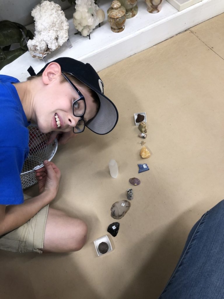 A boy with his choices of rocks lined up to buy from Johnson's rock shop