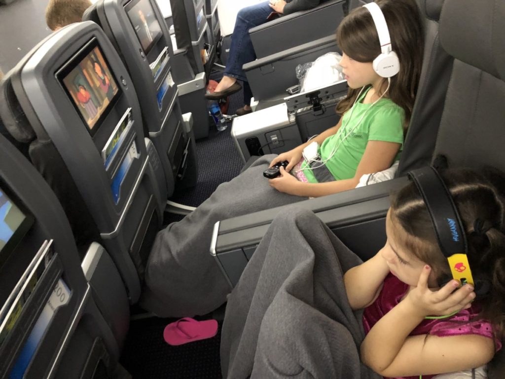 two girls Starring at the screens in Premium Economy Seating on an American Airlines flight