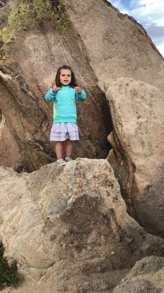 A little girl climbs boulders and sings at Castle Rock, Colorado