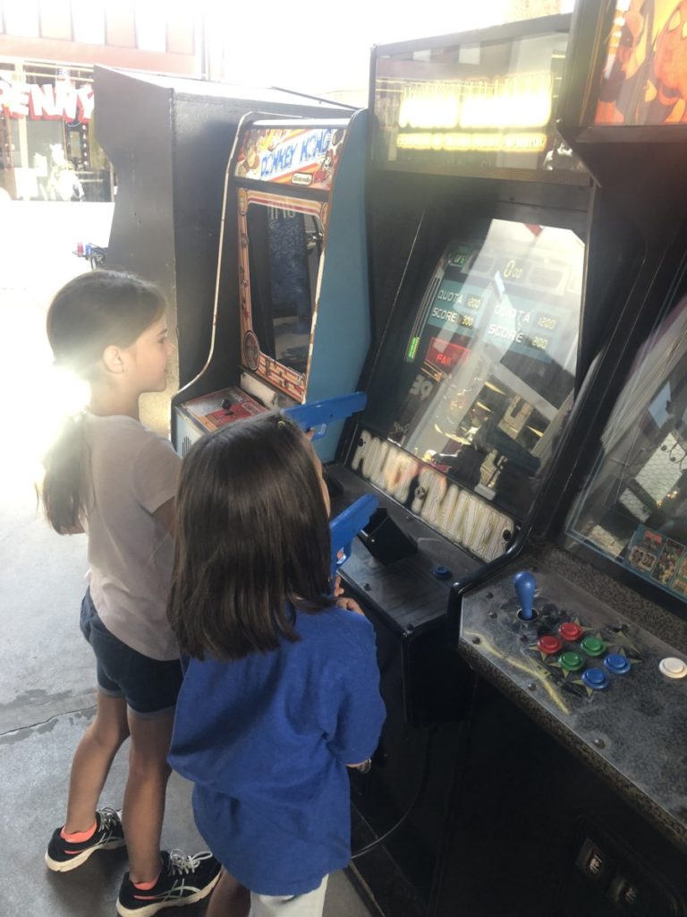 2 girls play on vintage arcades at the Penny arcades in Manitou Springs, Colorado
