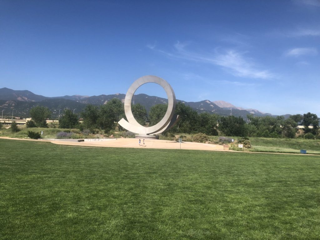 A large circular memorial structure at America the Beautiful Park in Colorado Springs with kids