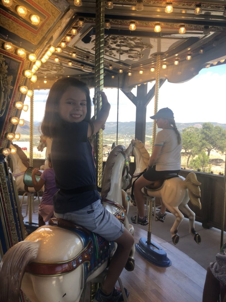 A girl rides the carousel at Tommy Knockers Playland at Royal Gorge and Bridge Park