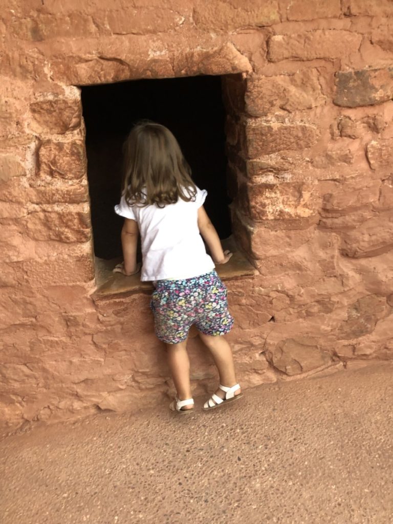 A toddler looks into the Manitou Cliff Dwellings in Colorado Springs with kids
