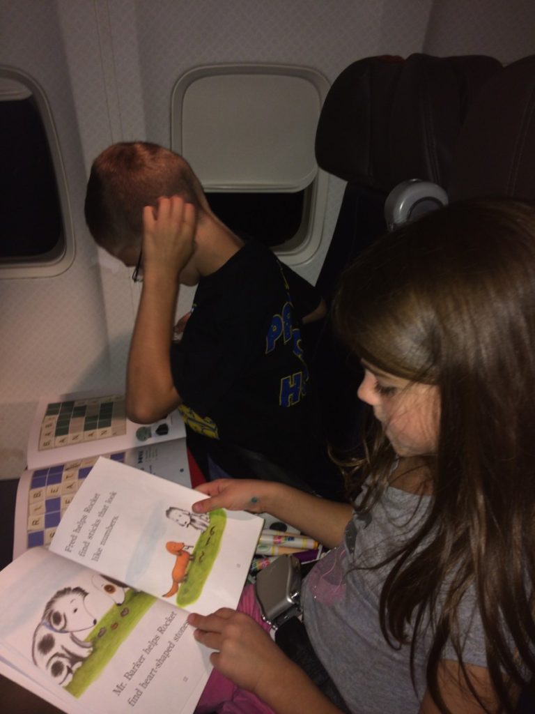 2 kids read books. What to do on a flight with kids