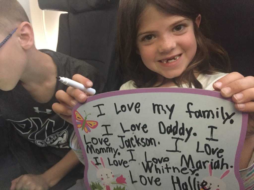 a girls writes on a white board as Airplane entertainment for kids