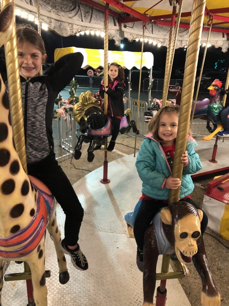 3 girls on the carousel at Prairie Lights