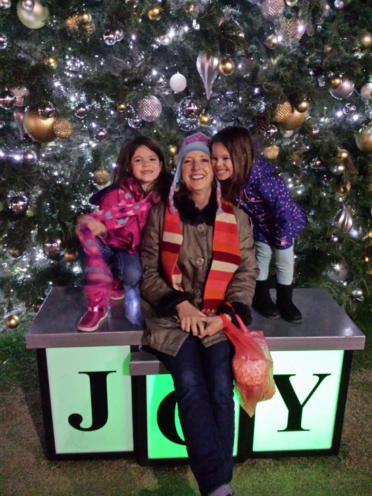 Grandma sits with 2 girls in front of a Christmas tree in Grapevine