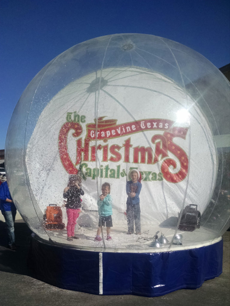 3 kids in a life size snow globe in Grapevine Texas