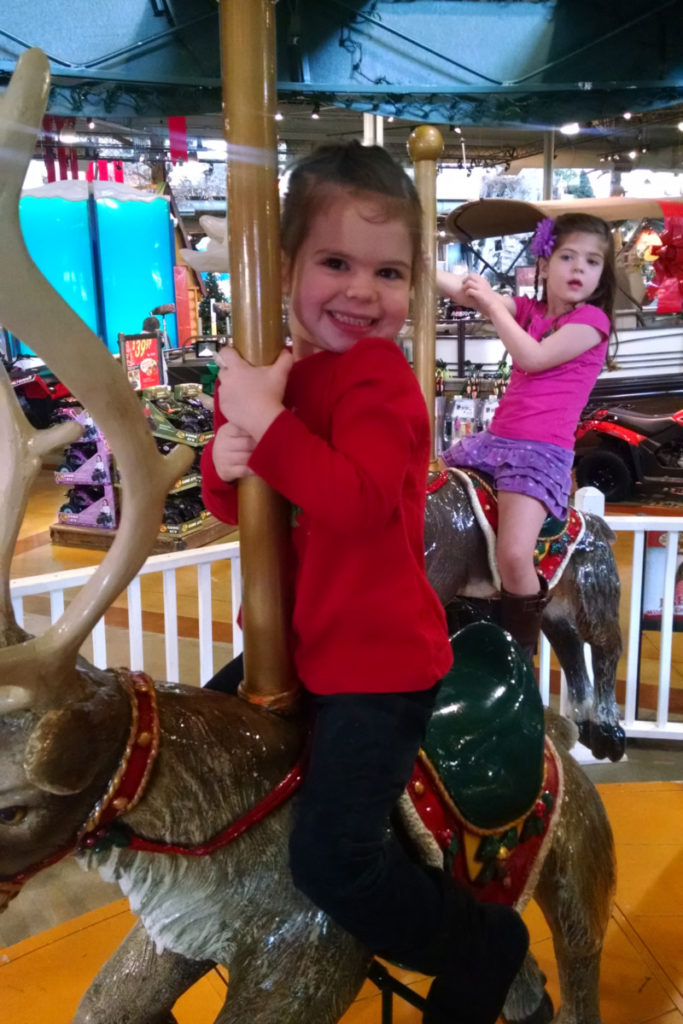 2 girls on Christmas Carousel at Bass Pro