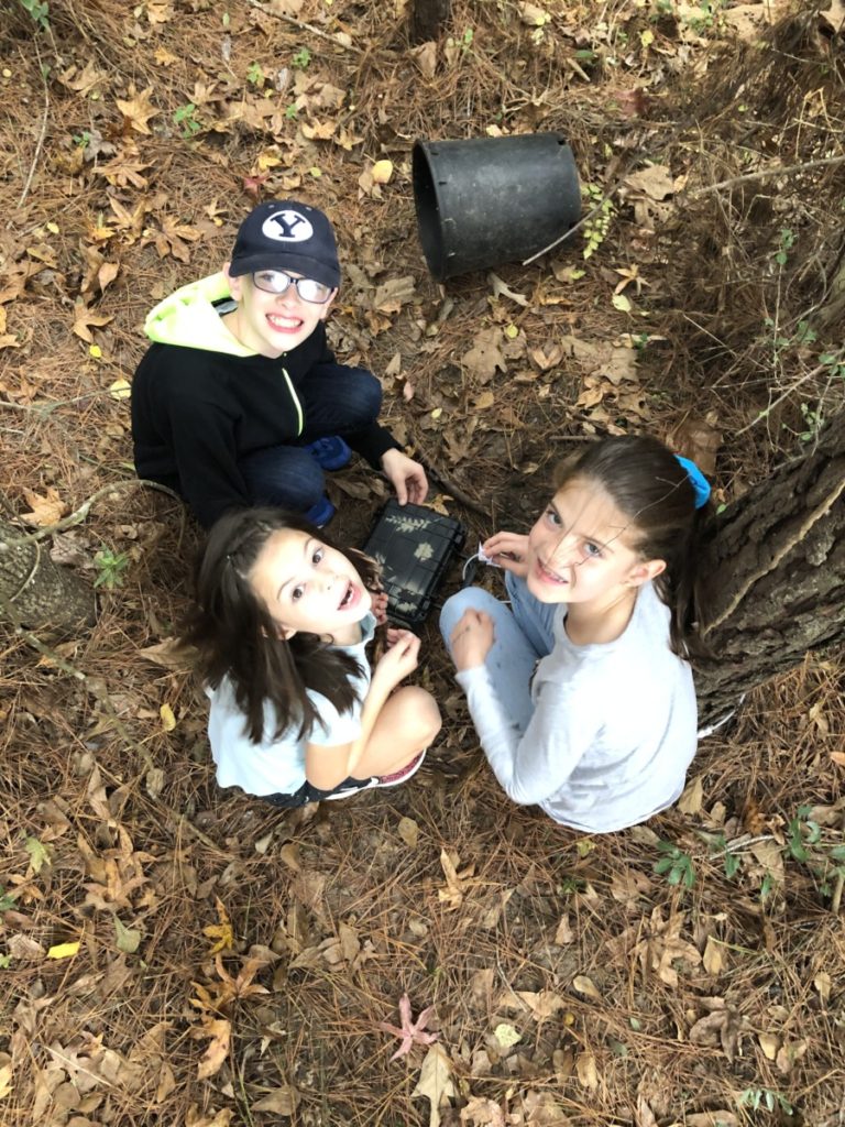 3 kids in the woods finding a Geocache on the Geo Tour in Conroe Texas