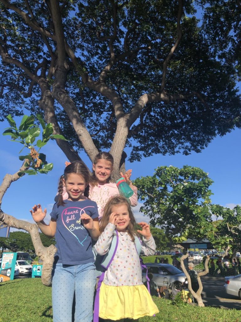 3 girls in front of a Hawaiian tree at the Kona Airport