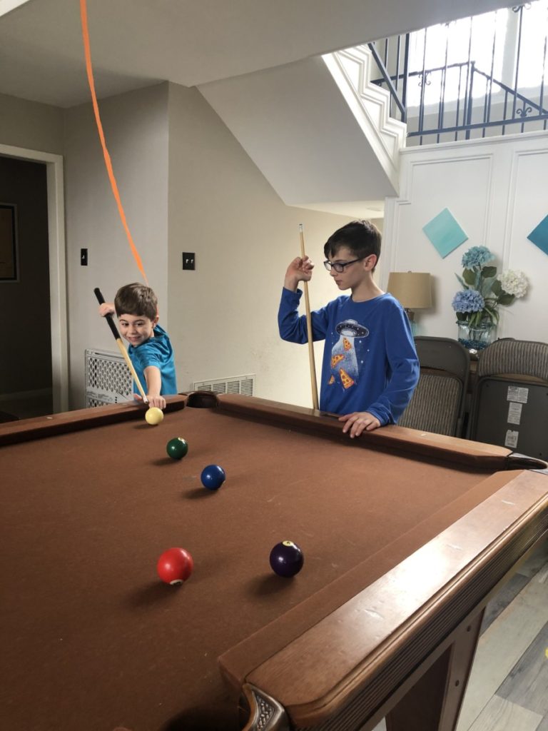 2 young boys playing pool at Simply the Best Home at Texoma Luxury Rental Properties