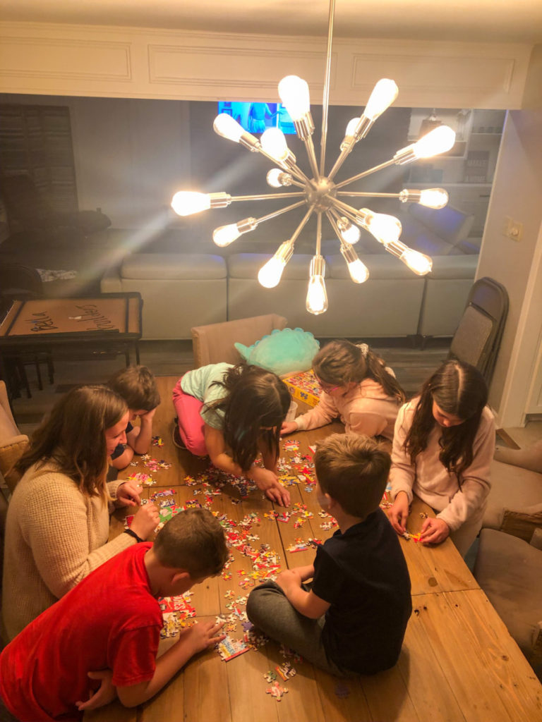 7 kids work on a puzzle on the table at Texoma Luxury Rentals house