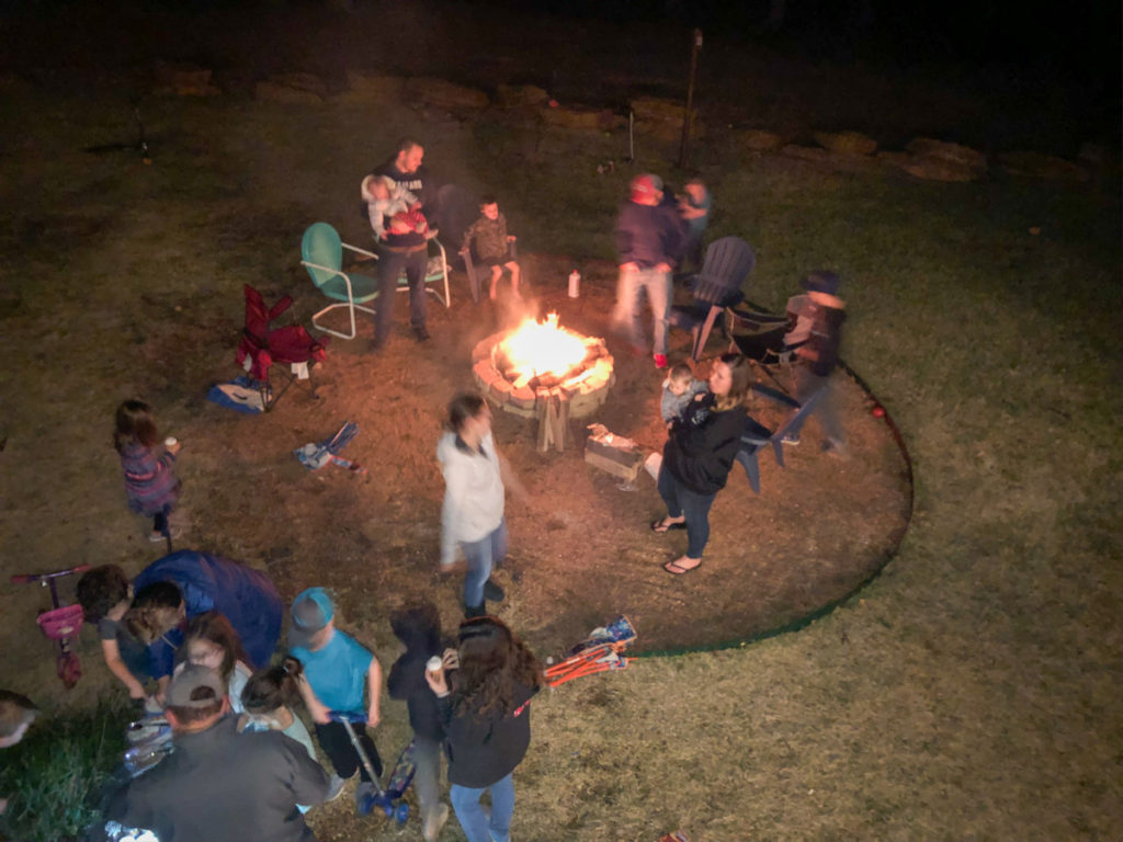 Friends gather around the fire pit at Simply the Best house Texoma luxury Rentals