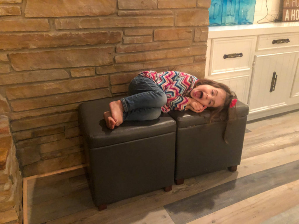 a young girls lays on ottoman cubes at Texoma Luxury Rentals house